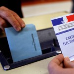 A man casts his vote in the ballot box in a polling in Montpellier as France goes to the polls in the first round of regional elections