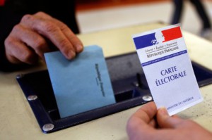 A man casts his vote in the ballot box in a polling in Montpellier as France goes to the polls in the first round of regional elections
